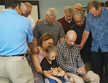 Concord Baptist Association pastors pray over Ukrainian Pastor Elisey Pronin, wife Oksana and 5-year-old son David after Pronin shared his story at the association office in Jefferson City, Mo., on May 27. (Vicki Brown photo)