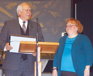 Missouri Baptist Convention Executive Director John Yeats (left) presents Tanya McMillan, administrative assistant for the Church Strengthening Team, with a plaque recognizing her 25 years as a convention employee. The convention also presented her with flowers. She has served in various roles since joining the convention staff Jan. 1, 1990.