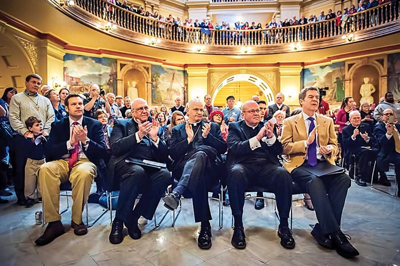 Kansas Gov. Sam Brownback, at far right, and three bishops attend the religious freedom rally on Feb. 17, 2016, in Topeka, Kan. Archbishop Joseph F. Naumann of Kansas City, from left, Bishop Edward J. Weisenburger of Salina, and Bishop Carl A. Kemme, of Wichita attended with Brownback. Photo courtesy of Joe Bollig/The Leaven