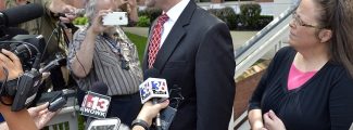 Rowan County Clerk Kim Davis, right, listens as her attorney Roger Gannam addresses the media on the steps of the U.S. District Court for the Eastern District of Kentucky in Covington on July 20, 2015. Davis, who has said she cannot issue marriage licenses to same-sex couples because it would violate her religious beliefs, is being sued by the American Civil Liberties Union on the behalf of two gay couples and two straight couples. (AP Photo/Timothy D. Easley)