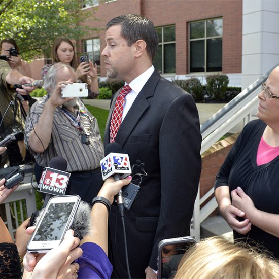 Rowan County Clerk Kim Davis, right, listens as her attorney Roger Gannam addresses the media on the steps of the U.S. District Court for the Eastern District of Kentucky in Covington on July 20, 2015. Davis, who has said she cannot issue marriage licenses to same-sex couples because it would violate her religious beliefs, is being sued by the American Civil Liberties Union on the behalf of two gay couples and two straight couples. (AP Photo/Timothy D. Easley)