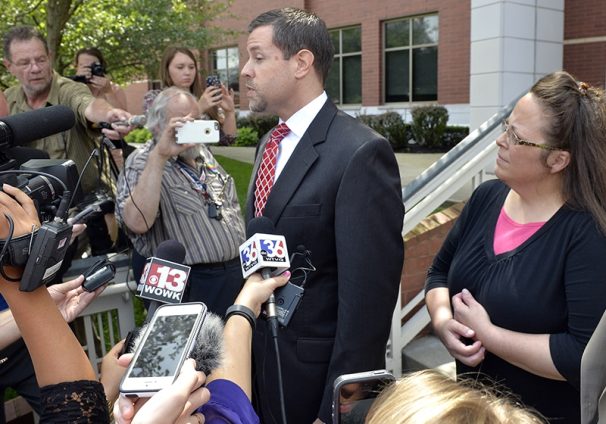 Rowan County Clerk Kim Davis, right, listens as her attorney Roger Gannam addresses the media on the steps of the U.S. District Court for the Eastern District of Kentucky in Covington on July 20, 2015. Davis, who has said she cannot issue marriage licenses to same-sex couples because it would violate her religious beliefs, is being sued by the American Civil Liberties Union on the behalf of two gay couples and two straight couples. (AP Photo/Timothy D. Easley)
