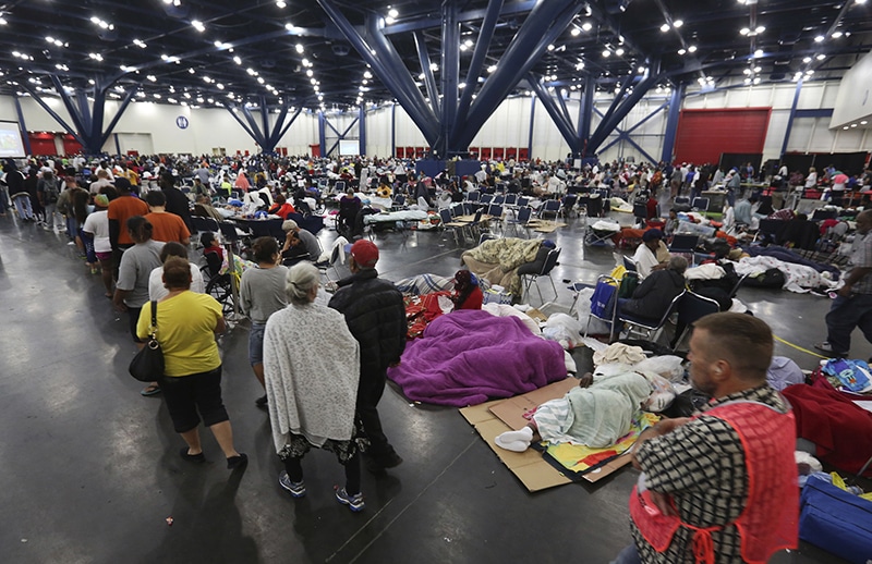 People line up for food as others rest at the George R. Brown Convention Center that has been set up as a shelter for evacuees escaping the floodwaters from Tropical Storm Harvey in Houston on Aug. 29, 2017. (AP Photo/LM Otero)