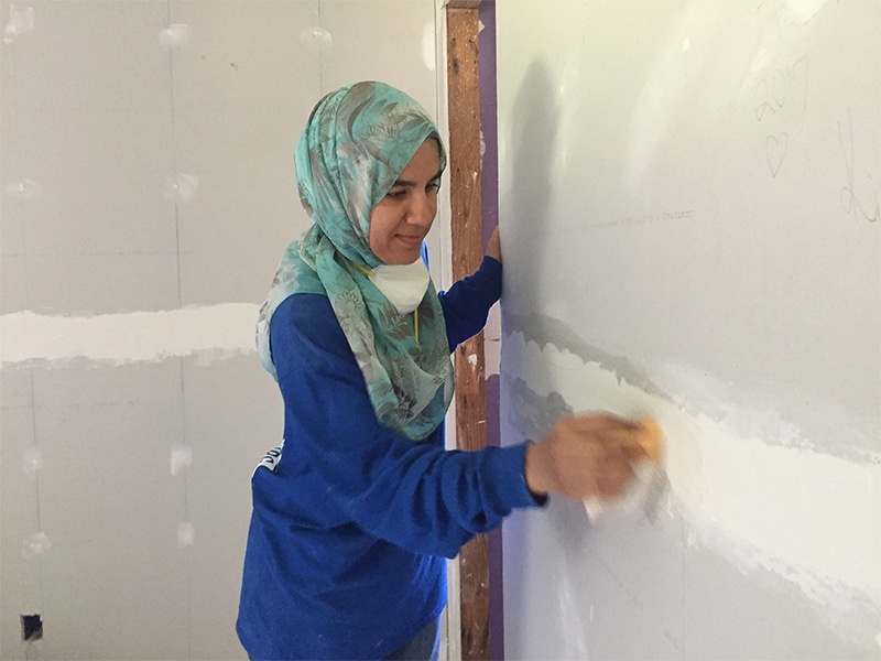 Amaney Kazlak of Jersey City, N.J.,, an Islamic Relief USA volunteer, uses a sanding sponge to smooth out the newly installed drywall in a home in Princeville, N.C. RNS photo by Yonat Shimron