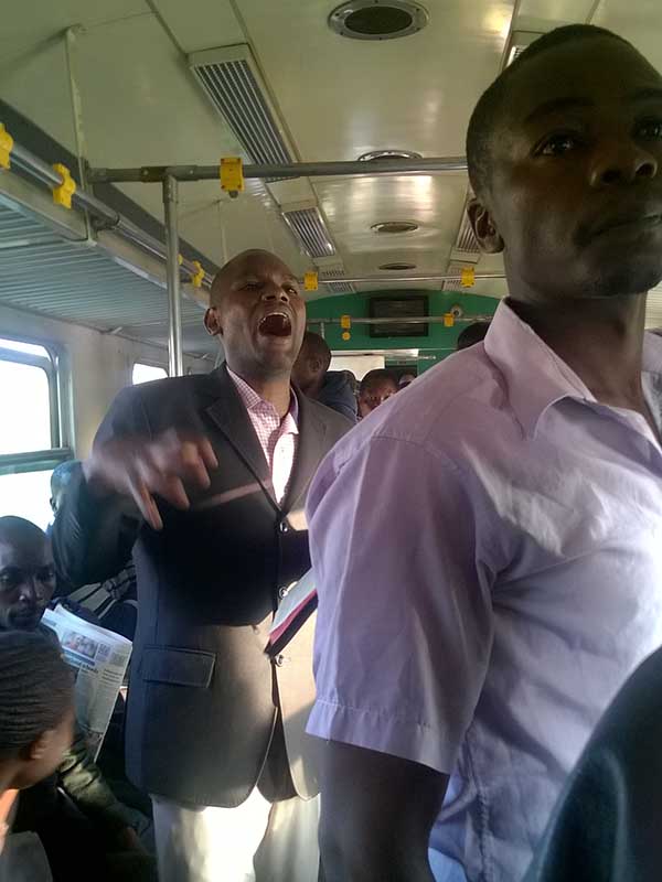 A preacher delivering the sermon on one of the coaches to Nairobi, Kenya, on Sept. 27, 2017. Several preachers lead worship on the train. Photo by Fredrick Nzwili