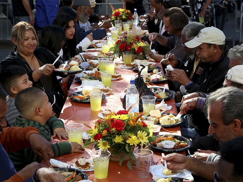People sit down for an early Thanksgiving meal served to the homeless and others at Los Angeles Mission on skid row in Los Angeles, California on Nov. 27, 2013. More than 3,500 meals were served to those in need. Photo courtesy of REUTERS/Jonathan Alcorn