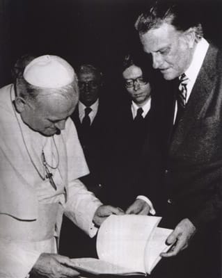 Billy Graham presents a book to Pope John Paul II during an audience on Jan 12., 1981, at the Vatican. Graham gave the pontiff photo albums of the Philippines and Japan — countries that the pope visited shortly after that. Religion News Service file photo