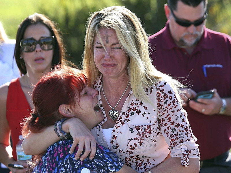 Parents wait for news after a shooting at Marjory Stoneman Douglas High School in Parkland, Fla., on Wednesday, Feb. 14, 2018. Nikolas Cruz, a former student, was charged with 17 counts of premeditated murder Thursday morning. (AP Photo/Joel Auerbach)
