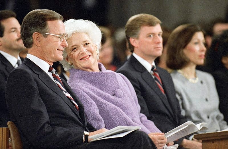 First lady Barbara Bush, second from left, leans over to talk with her husband, President George H.W. Bush, left, during the National Prayer Service at the Washington Cathedral on Jan. 22, 1989, in Washington, D.C. At right is Vice President Dan Quayle and his wife, Marilyn Quayle. (AP Photo/Doug Mills)