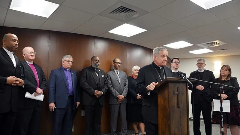 Religious leaders from a variety of faiths join Archbishop Robert J. Carlson, at podium, to express opposition to a Missouri bill that would permit people to carry concealed firearms in church, during a news conference in St. Louis, on April 11, 2018. Photo courtesy of Fred Koenig