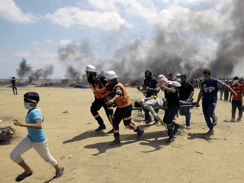Palestinian medics and protesters evacuate a wounded youth during a protest at the Gaza Strip’s border with Israel, east of Khan Younis, Gaza Strip, on May 14, 2018. Thousands of Palestinians are protesting near Gaza’s border with Israel, as Israel prepared for the festive inauguration of a new U.S. Embassy in contested Jerusalem. (AP Photo/Adel Hana)