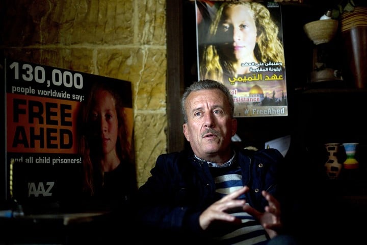 Palestinian Bassem Tamimi speaks in front of posters showing his daughter Ahed at his home in Nabi Saleh near the West Bank city of Ramallah, on Jan. 5, 2018. Israel’s hard-charging prosecution of his 16-year-old daughter who slapped two Israeli soldiers has trained a spotlight on her activist family and its role in what Palestinians call “popular resistance,” or near-weekly protests against Israeli occupation staged in several West Bank villages. (AP Photo/Majdi Mohammed)