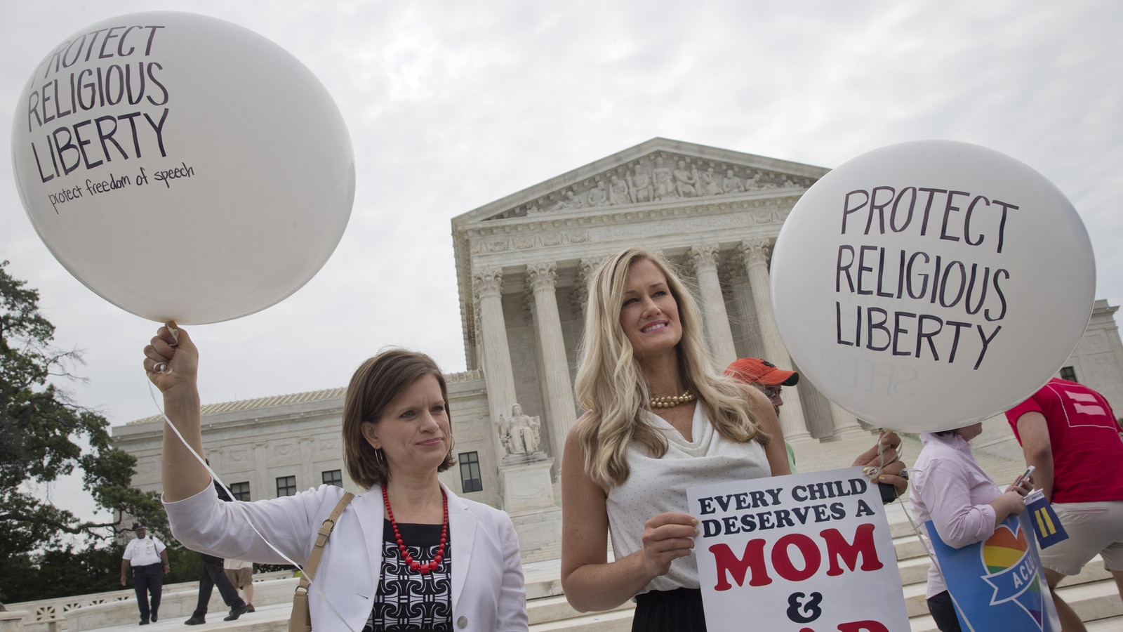 Jennifer Marshall (left), with the Heritage Foundation, and Summer Ingram, with the Congressional Prayer Caucus Foundation, who said they support "traditional marriage" hold balloons that says "protect religious liberty" outside of the Supreme Court Friday June 26, 2015, in Washington. (AP Photo/Jacquelyn Martin)