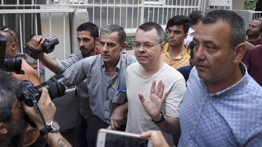 Pastor Andrew Craig Brunson, a 50-year-old evangelical pastor from Black Mountain, North Carolina, center, waves as he leaves a prison outside Izmir, Turkey, on July 25, 2018. Brunson, who had been jailed in Turkey for more than 1 ½ years on terror and espionage charges, was released Wednesday and will be put under house arrest as his trial continues. Pastor Brunson was let out of jail to serve home detention because of "health problems," Turkey's official Anadolu news agency said. (DHA via AP)