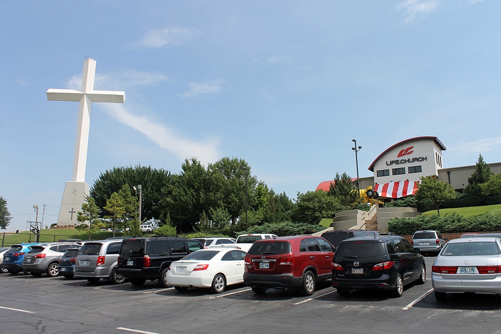 Drivers headed north on Interstate 35 can’t miss the massive white cross at the Life Church campus in Edmond, Okla. The multisite evangelical church, which each weekend draws 75,000 worshippers to 29 locations in nine states, has an $8.3 million annual budget for the YouVersion app, a ministry of the church. RNS photo by Bobby Ross Jr.