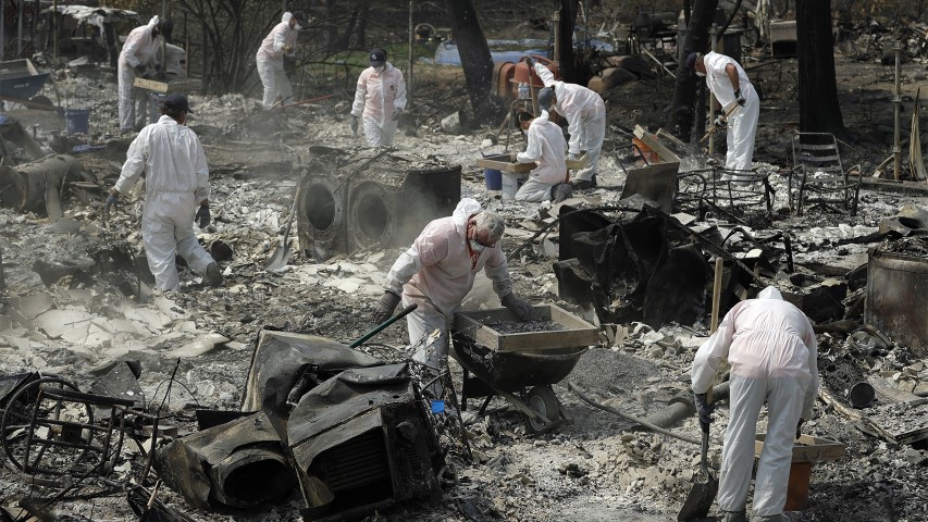 Volunteers with Samaritan's Purse sift through the charred remains of a home burned in the Carr Fire on Aug. 10, 2018, in Redding, Calif. (AP Photo/John Locher)