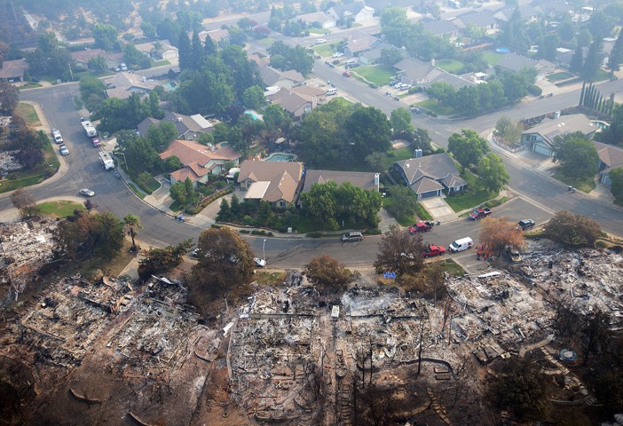 Homes destroyed by a wildfire are seen from an aerial view in the Keswick neighborhood of Redding, Calif., on Aug. 10, 2018. Fire crews have made progress against the biggest blaze in California history but officials say the fire won’t be fully contained until September. (AP Photo/Michael Burke)