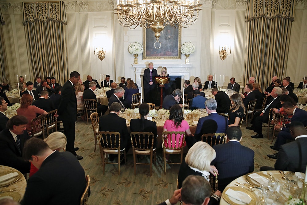 President Donald Trump bows his head in prayer as pastor Paula White leads the room in prayer during a dinner for evangelical leaders in the State Dining Room of the White House onAug. 27, 2018, in Washington. (AP Photo/Alex Brandon)