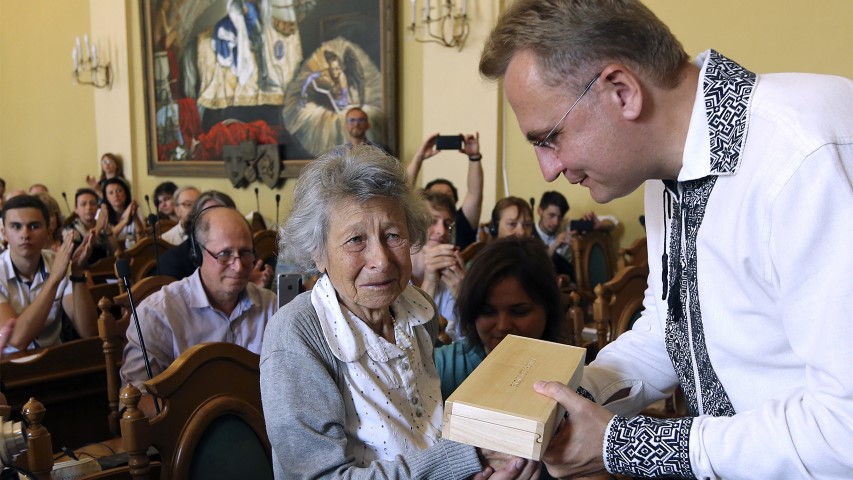 Andriy Sadoviy, right, the mayor of Lviv, Ukraine, presents a glass copy of an old metal synagogue key to Yanina Hescheles, Polish writer and a Nazi concentration camp survivor, at a ceremony Sept. 2, 2018, marking the 75th anniversary of the annihilation of the city's Jewish population by Nazi Germany. Lviv, once a major center of Jewish life in Eastern Europe, is commemorating the anniversary and honoring those working today to preserve that vanished world. The commemoration comes amid a larger attempt in Ukraine to preserve the memories of the prewar Jewish community. (AP Photo/Yevheniy Kravs)