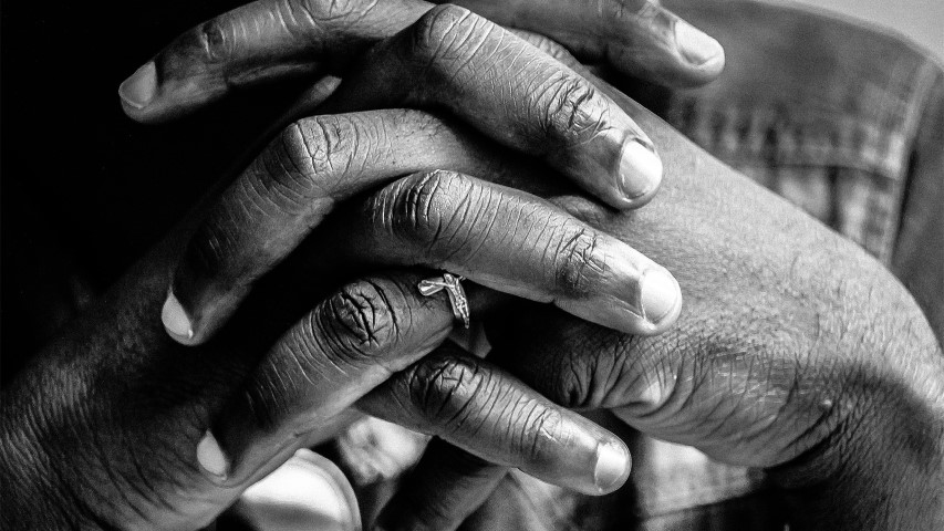 A man’s hands folded in prayer. Photo courtesy of Creative Commons