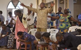 Rwandans sing and pray at the Evangelical Restoration Church in the Kimisagara neighborhood of the capital, Kigali, Rwanda, on April 6, 2014. Rwanda's government has closed numerous churches and mosques in 2018 as it seeks to assert more control over a vibrant religious community whose sometimes makeshift operations, authorities say, have threatened the lives of followers. (AP Photo/Ben Curtis)