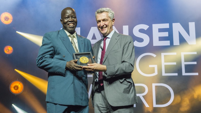 Dr. Evan Atar Adaha accepts the 2018 Nansen Refugee Award from UN High Commissioner for Refugees Filippo Grandi on Oct. 1, 2018. Atar runs the only functional hospital in Upper Nile State, South Sudan, where he and his team carry out an average of 58 operations per week with limited supplies and equipment. For more than 60 years, UNHCR’s Nansen Refugee Award has recognized those who show outstanding dedication to the refugee cause. © UNHCR/Mark Henley