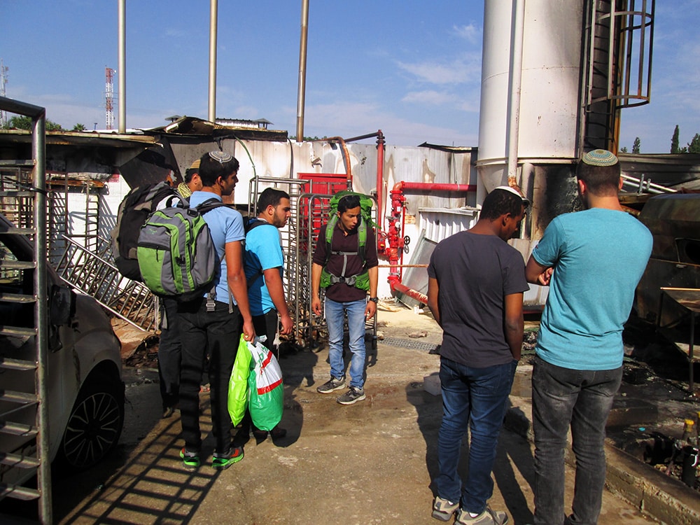 Students from a post-high-school yeshiva in Sderot check out what remains of a bakery that was hit by a rocket or mortar fired by Gaza militants. RNS photo by Michele Chabin