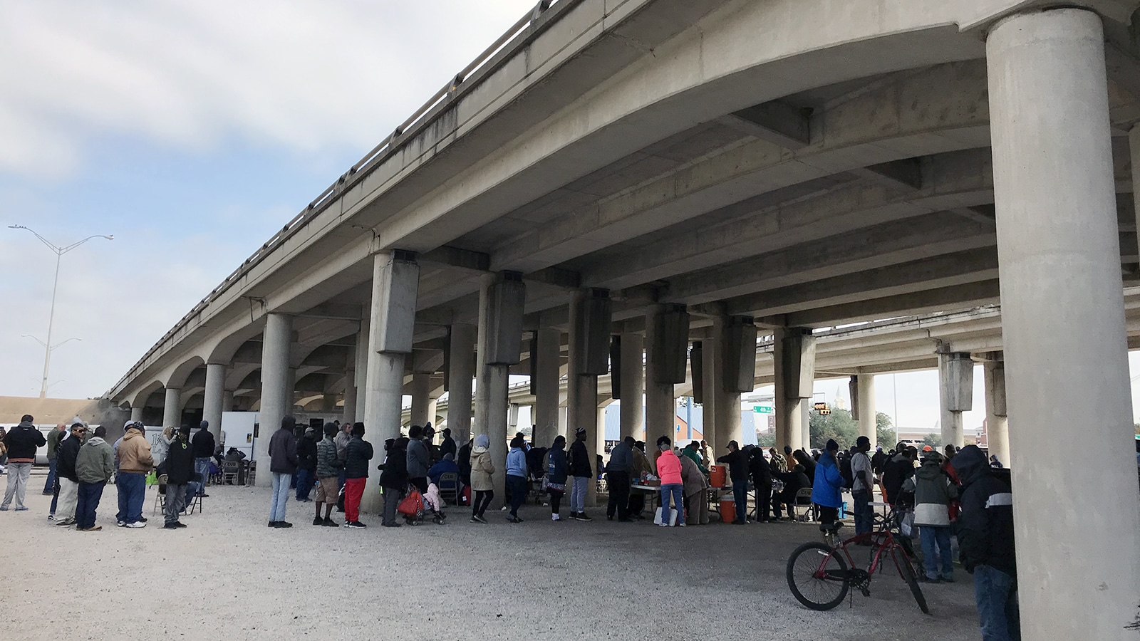 A crowd lines up for bowls of stew and other food options before worship at Church Under the Bridge in Waco, Texas, on Nov. 18, 2018. RNS photo by Bobby Ross Jr.