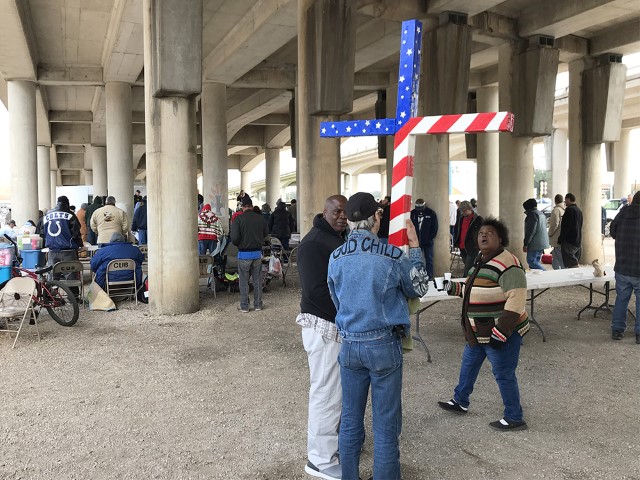 A man carries a star-spangled cross with him to worship at Church Under the Bridge in Waco, Texas, on Nov. 18, 2018. RNS photo by Bobby Ross Jr.
