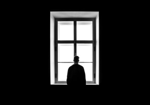 man looking out window