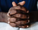 praying hands on Bible