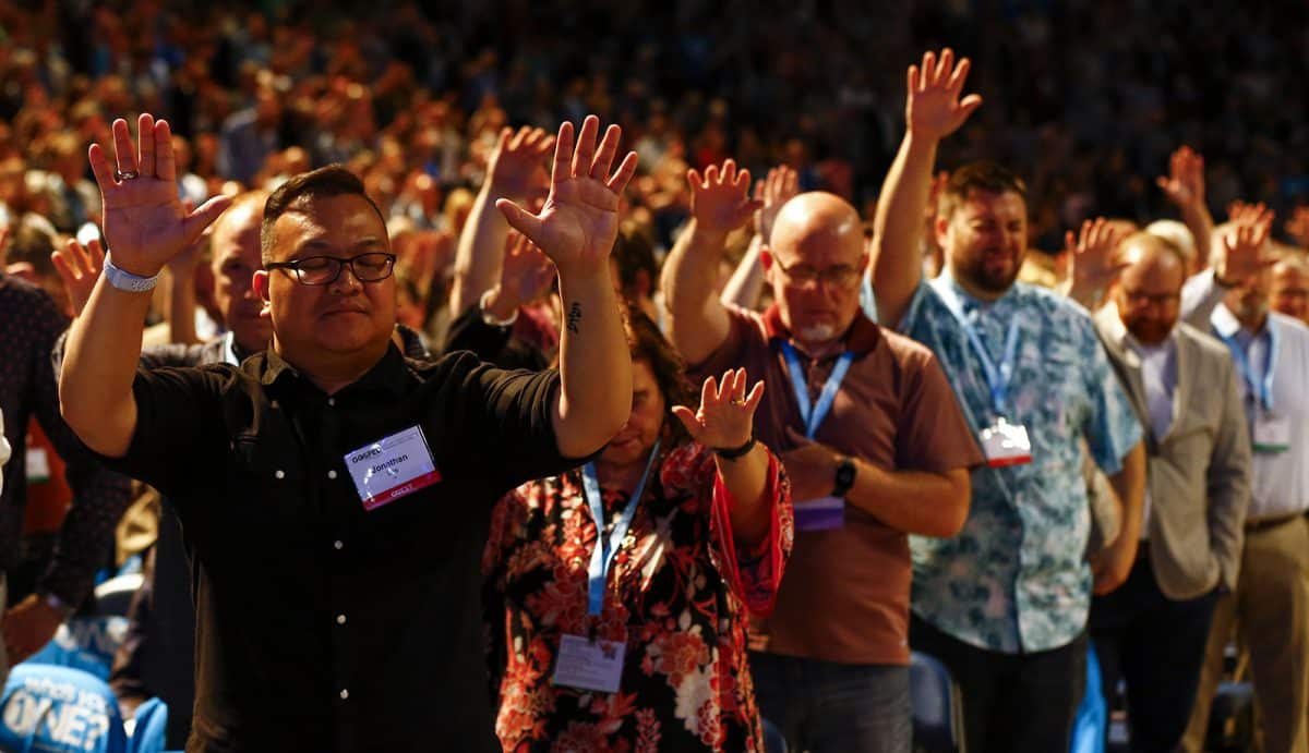 lifting hands in prayer at SBC annual meeting