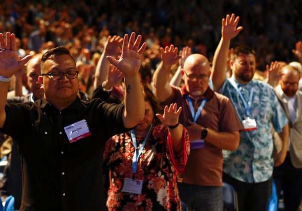 lifting hands in prayer at SBC annual meeting