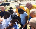 disaster relief team opray with hurricane victims