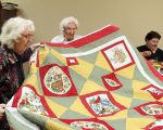 sisters holding up quilt