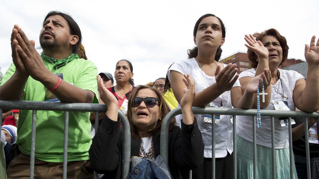 several people pray behind barricade