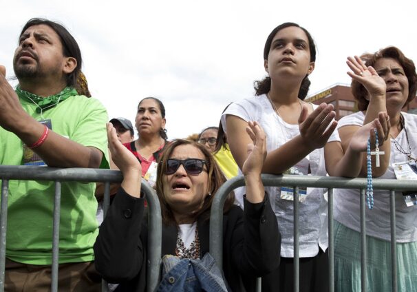 several people pray behind barricade