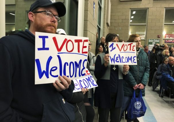 protestors holding pro-refugee signs