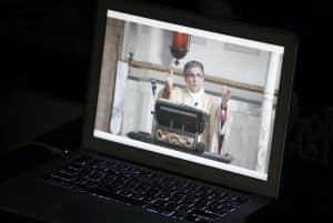 priest on laptop