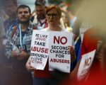 woman holding signs about abuse