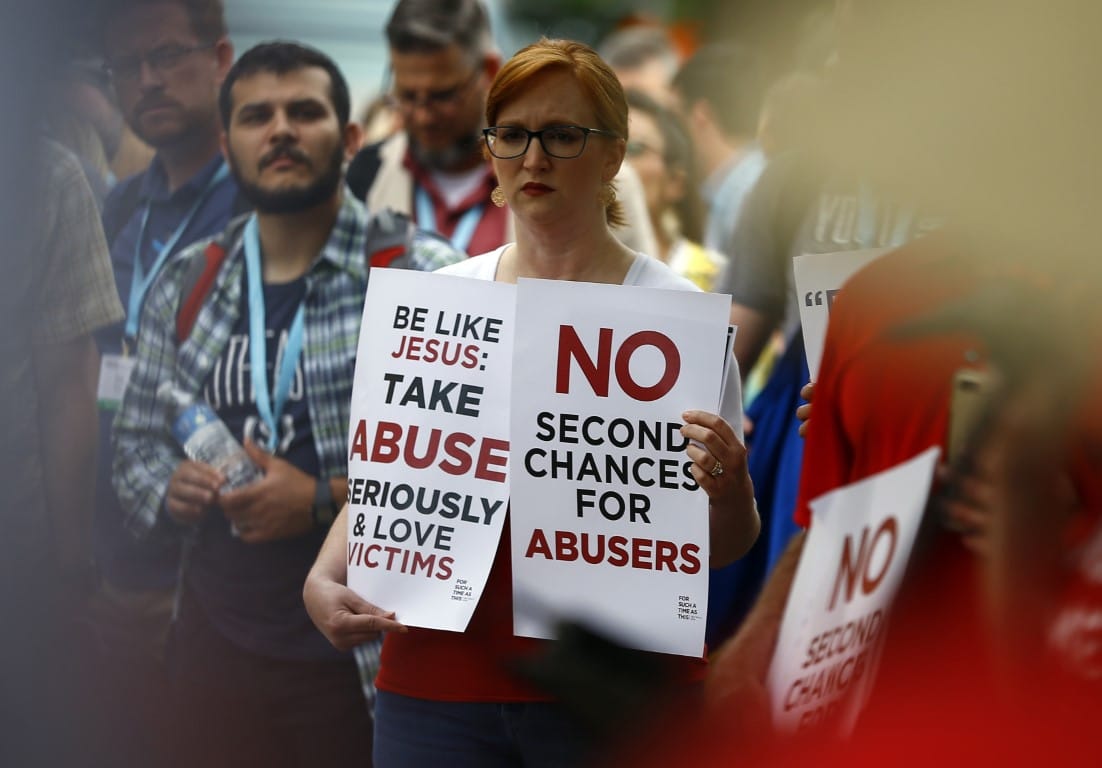 woman holding signs about abuse