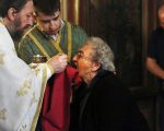 Greek Orthodox priest distributes Holy Communion