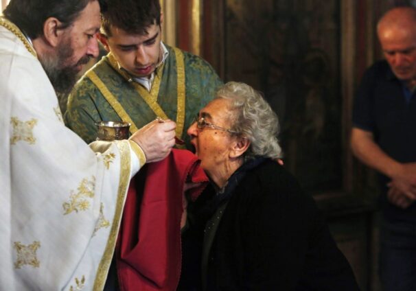 Greek Orthodox priest distributes Holy Communion
